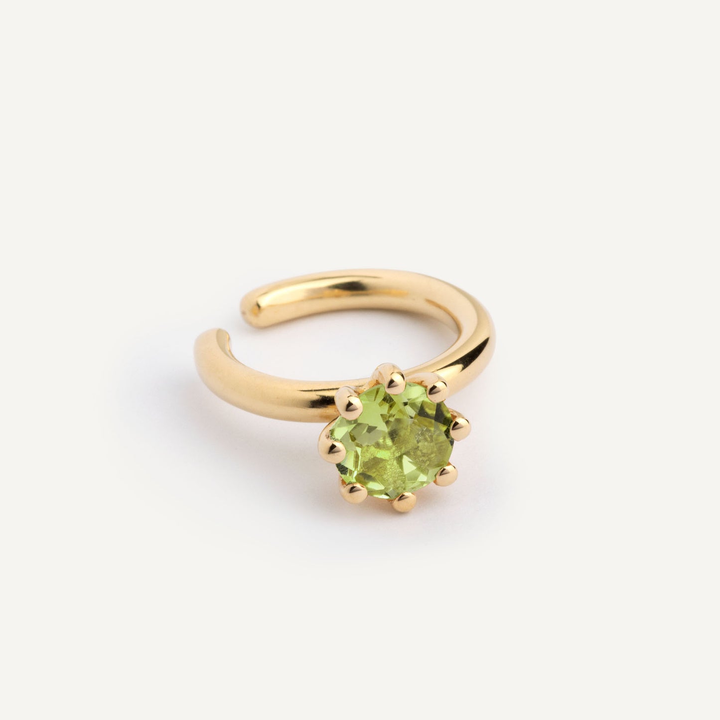 An ear cuff with Green Peridot gemstone, made of 18k yellow gold plated silver. Handmade in Barcelona. No piercing needed.