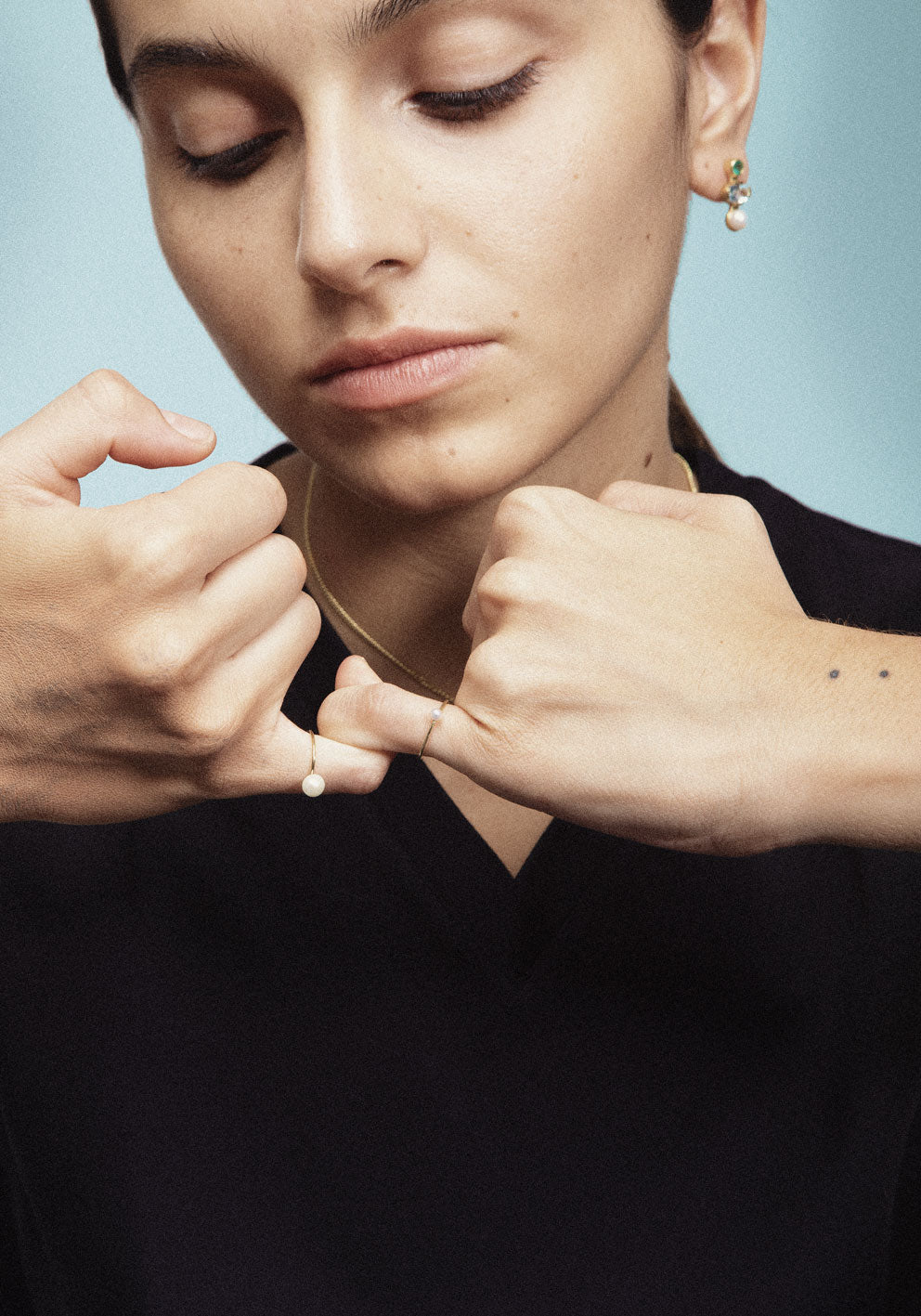 A pair of gold stud earrings featuring a combination of pearls, blue and green gemstones.