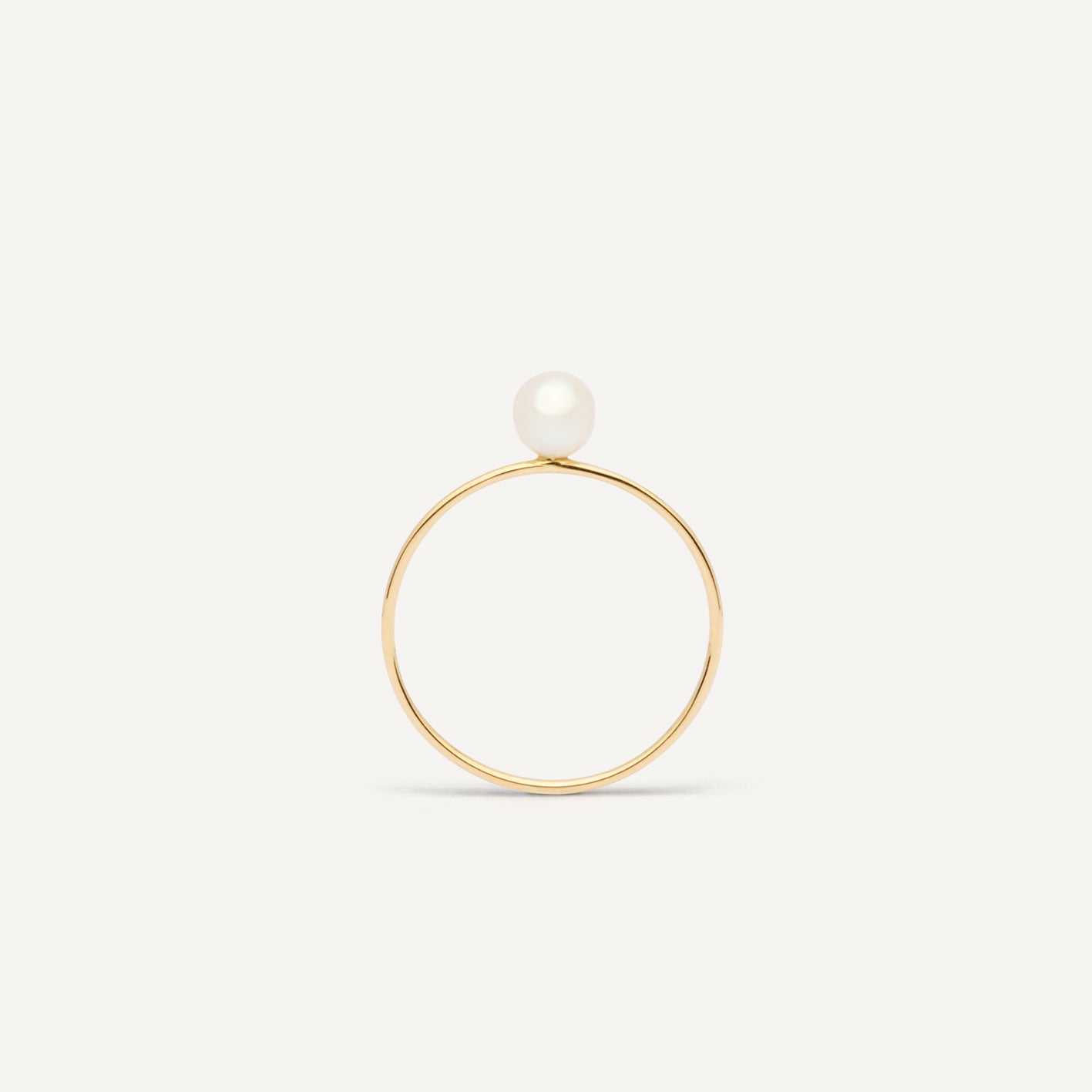 Thin gold pinkie ring featuring a white small pearl designed for everyday wear.  