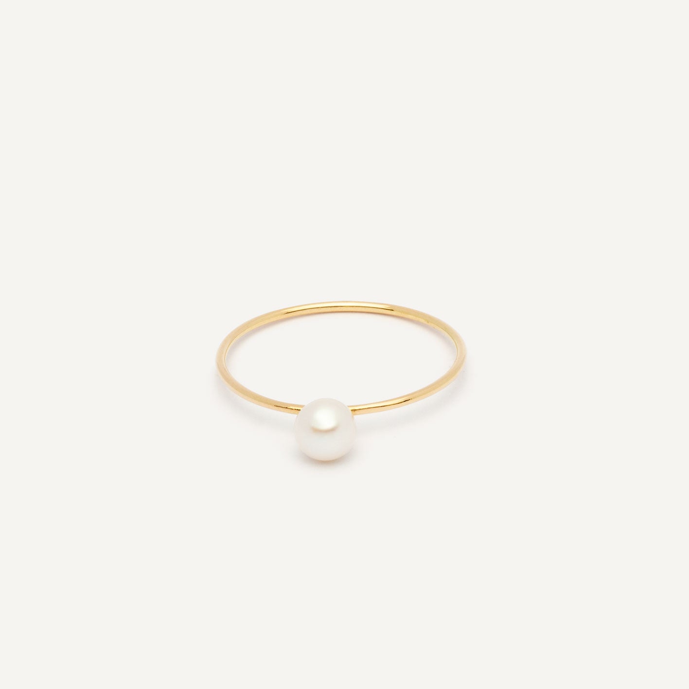 Thin gold pinkie ring featuring a white small pearl designed for everyday wear.  