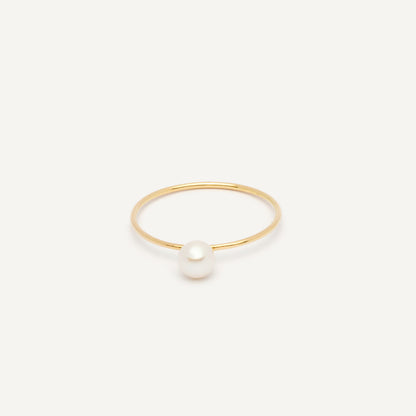 Thin gold pinkie ring featuring a white small pearl designed for everyday wear.  