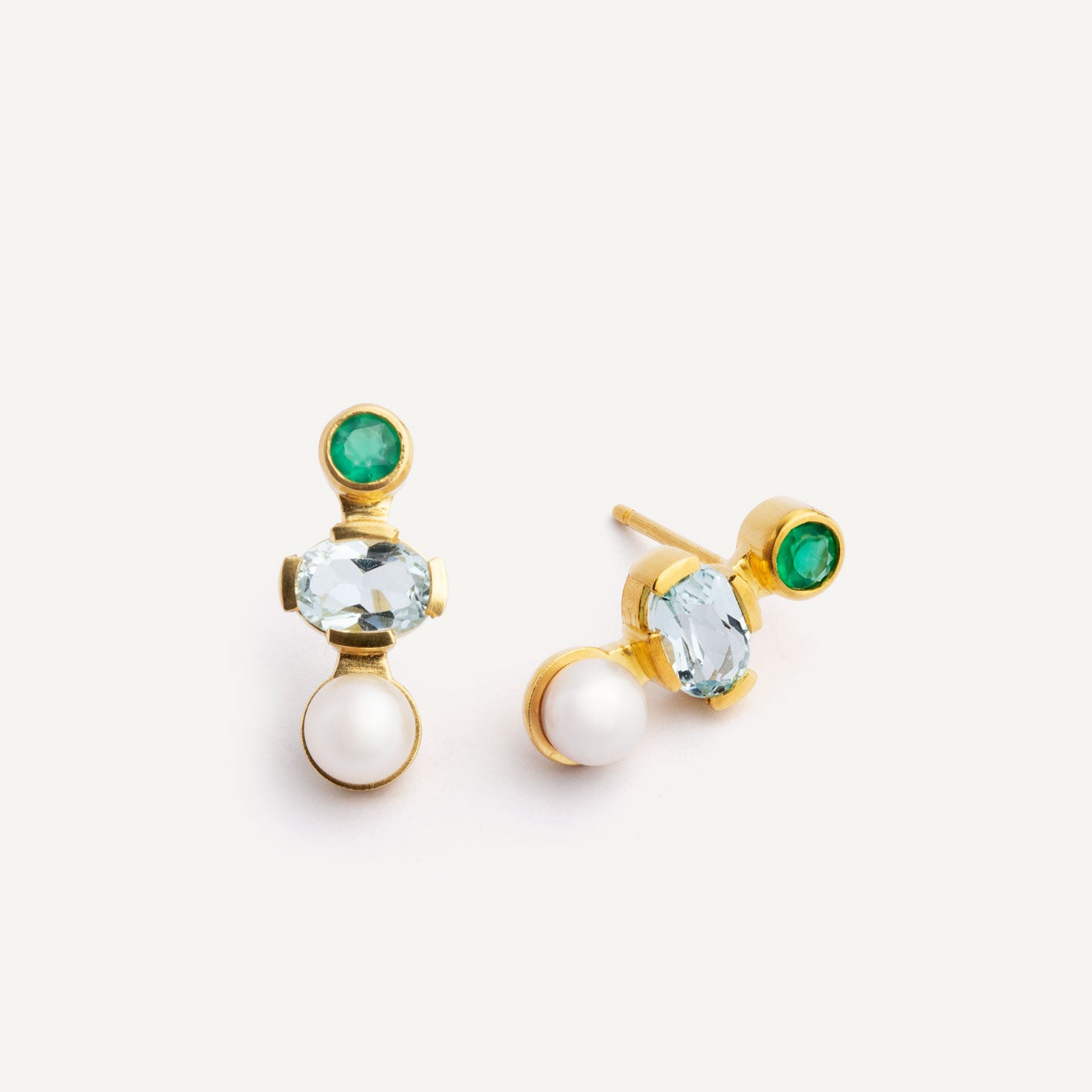 A pair of gold stud earrings featuring a combination of pearls, blue and green gemstones.