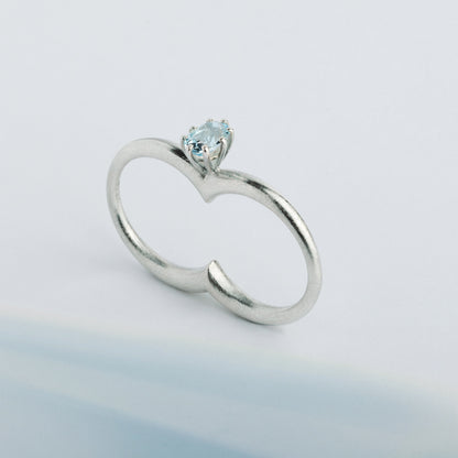A silver ring with a double circle and a blue gemstone designed for two fingers.