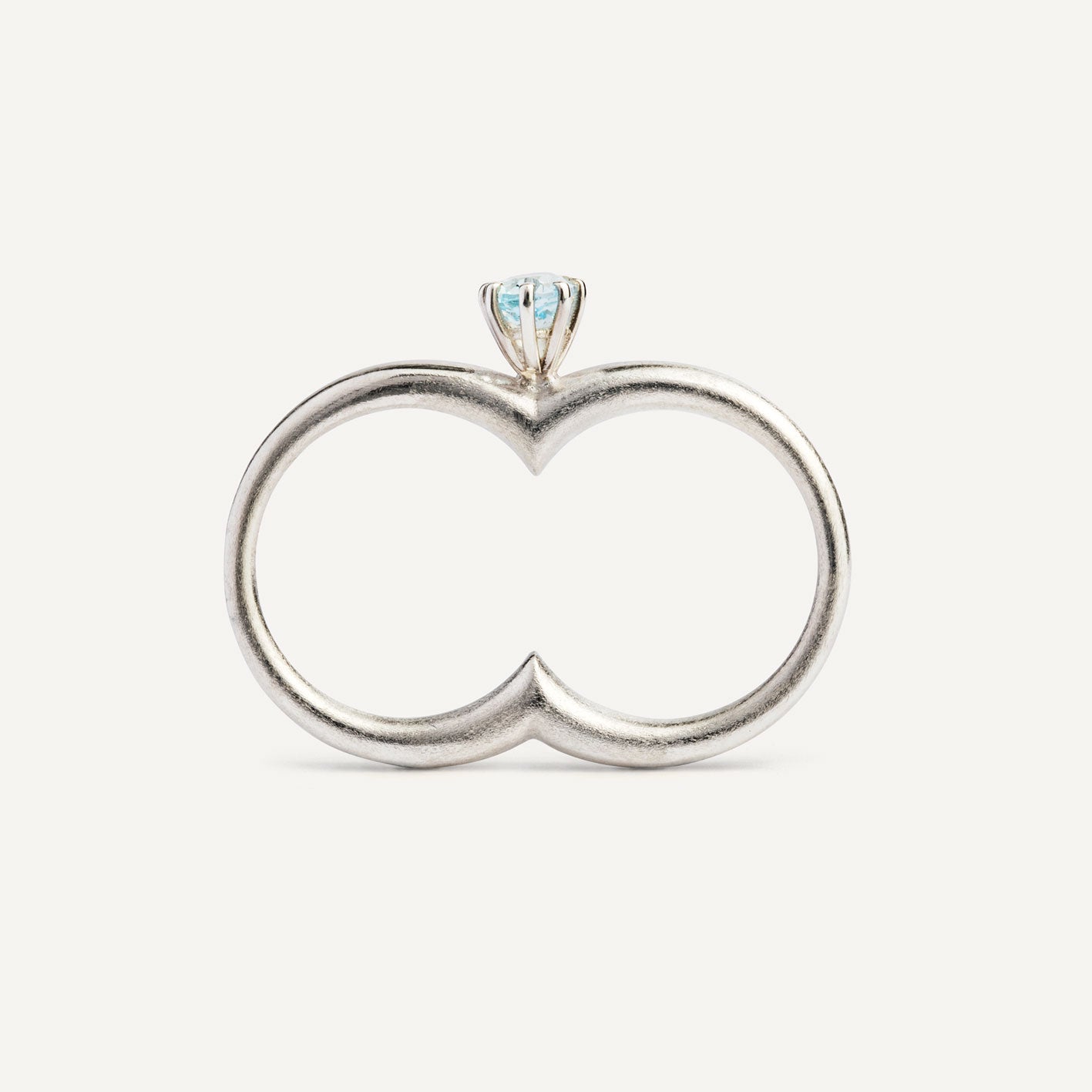 A silver ring with a double circle and a blue gemstone designed for two fingers.