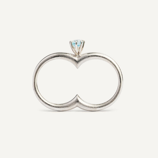 A silver ring with a double circle and a blue gemstone designed for two fingers.