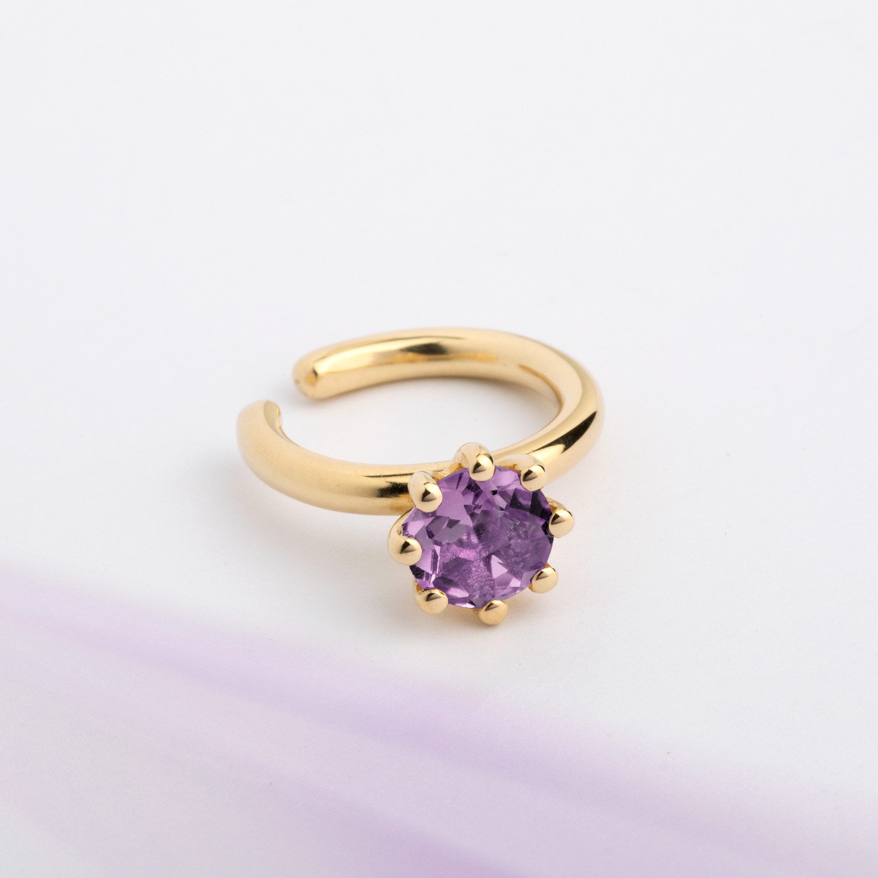 An ear cuff with violet Amethyst gemstone, made of 18k yellow gold plated silver. Handmade in Barcelona. No piercing needed. 