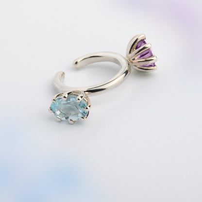 An ear cuff with 2 gemstones violet Amethyst and blue Topaz, made of silver. Handmade in Barcelona. No piercing needed. 