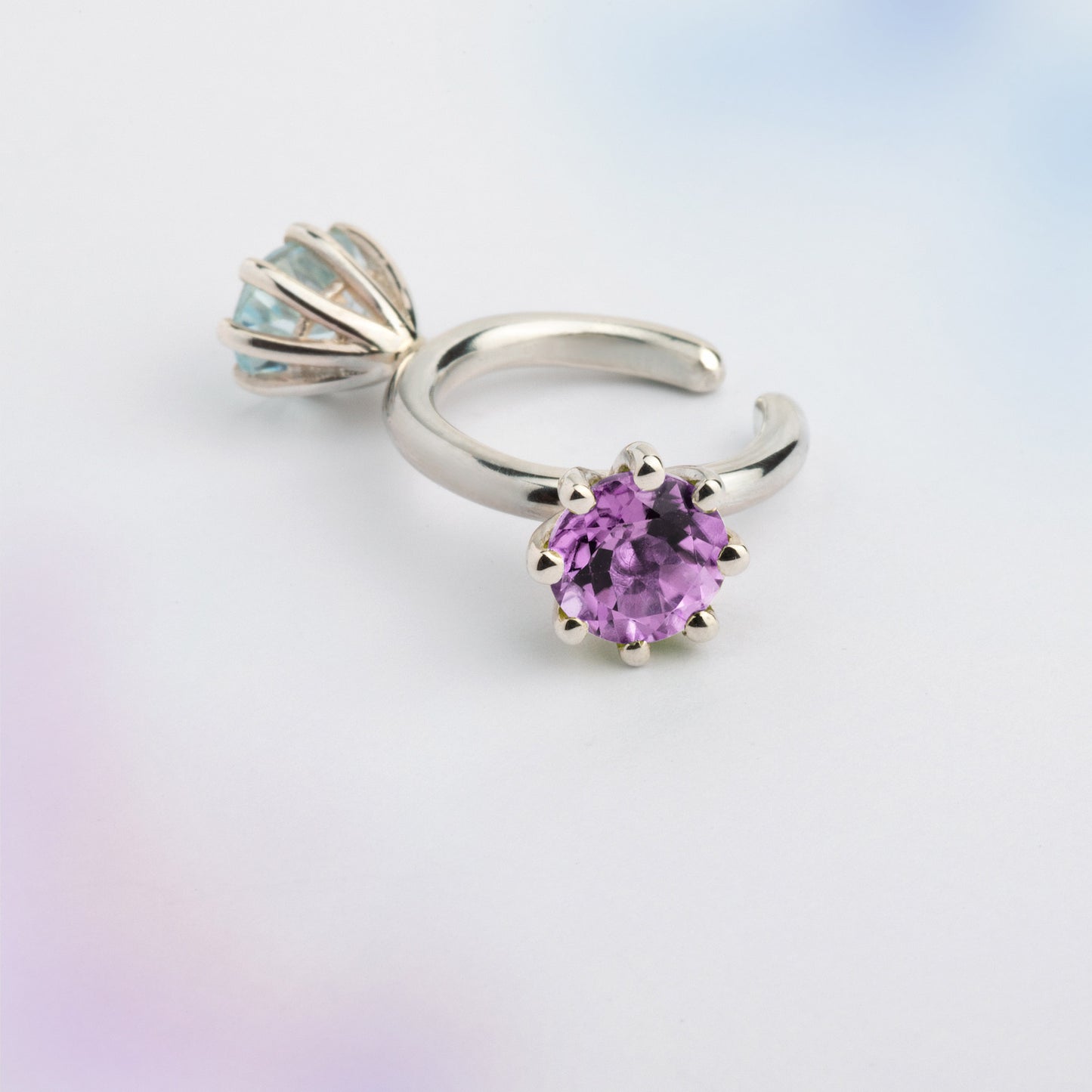 An ear cuff with 2 gemstones violet Amethyst and blue Topaz, made of silver. Handmade in Barcelona. No piercing needed. 
