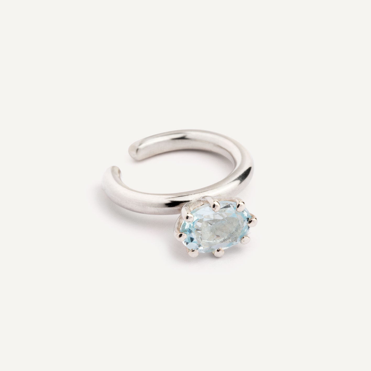 A ear cuff with Blue Topaz gemstone, made of silver. Handmade in Barcelona. No piercing needed. 