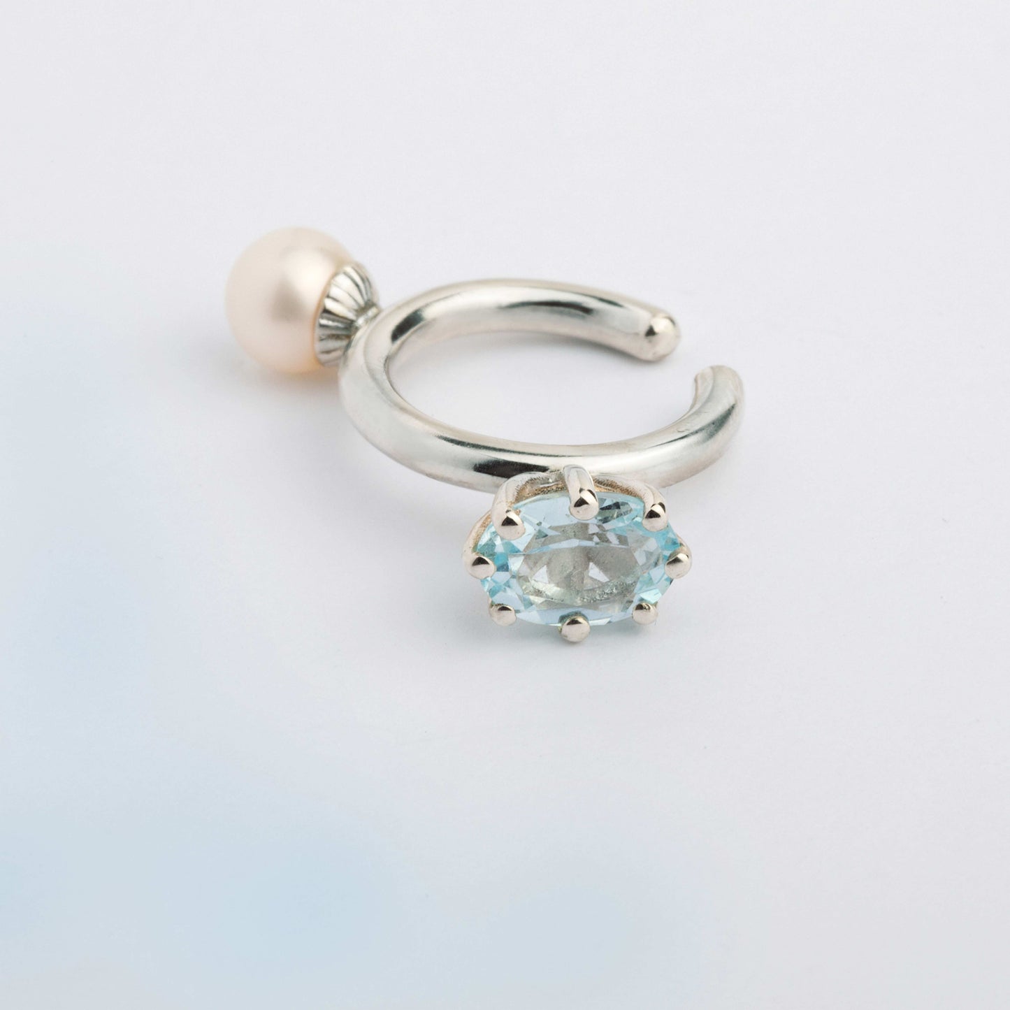 An ear cuff with 2 gemstones white Pearl and blue Topaz, made of silver. Handmade in Barcelona. No piercing needed. 