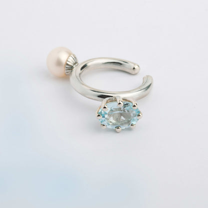 An ear cuff with 2 gemstones white Pearl and blue Topaz, made of silver. Handmade in Barcelona. No piercing needed. 