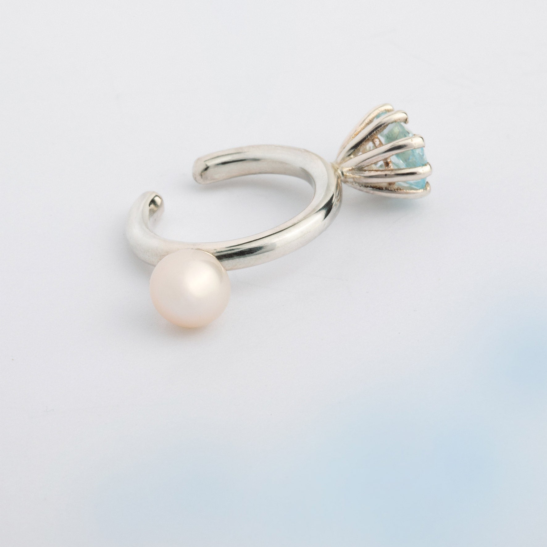 An ear cuff with 2 gemstones white Pearl and blue Topaz, made of silver. Handmade in Barcelona. No piercing needed. 