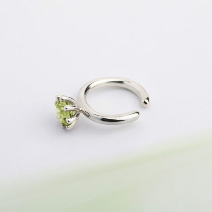 An ear cuff with green Peridot gemstone, made of silver. Handmade in Barcelona. No piercing needed. 