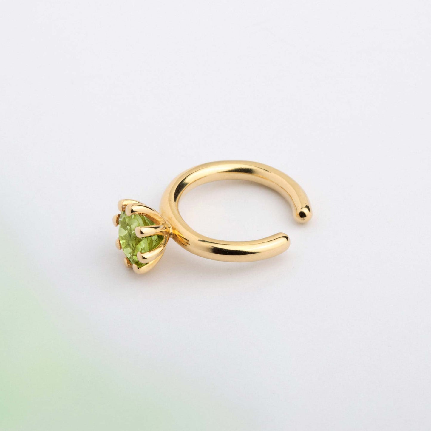 An ear cuff with Green Peridot gemstone, made of 18k yellow gold plated  silver. Handmade in Barcelona. No piercing needed. 