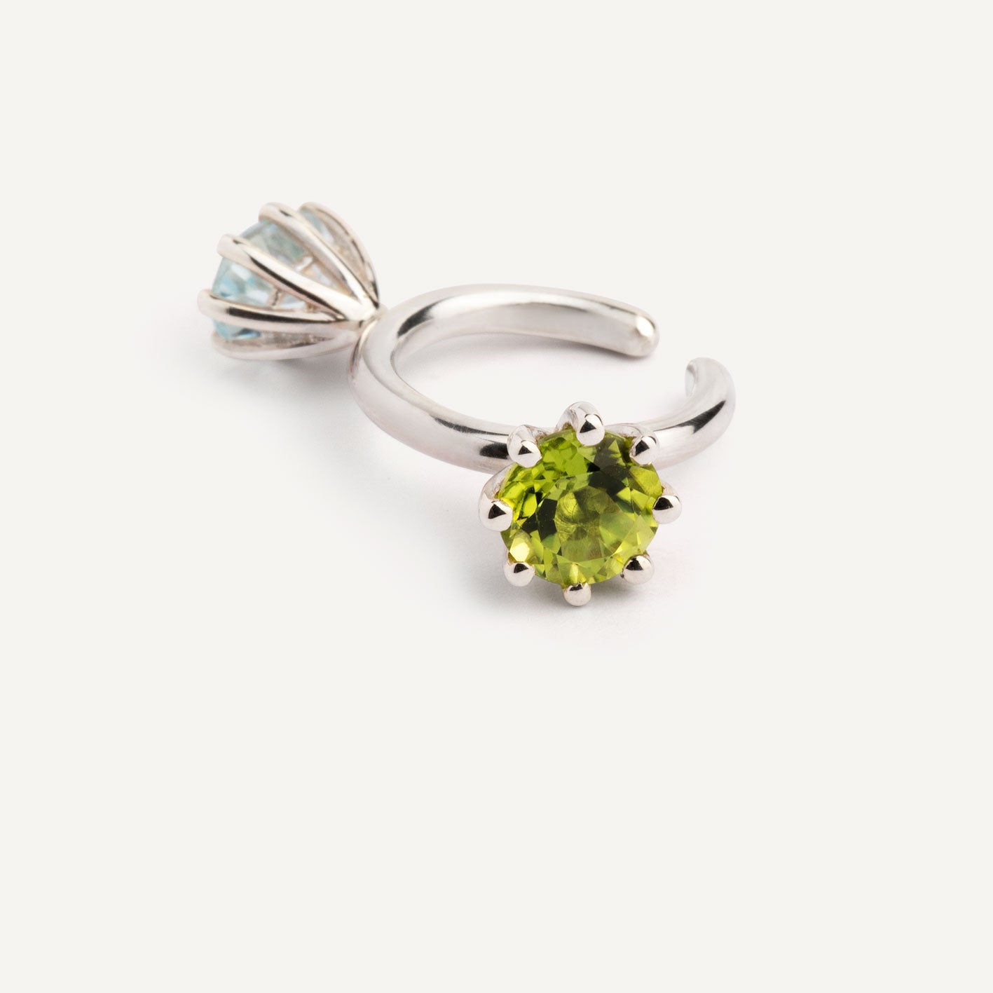 An ear cuff with 2 gemstones green Peridot and blue Topaz, made of silver. Handmade in Barcelona. No piercing needed. 