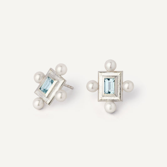 A pair of silver earrings featuring a geometric design with a central blue gemstone surrounded by pearls, set in a rectangular shape.