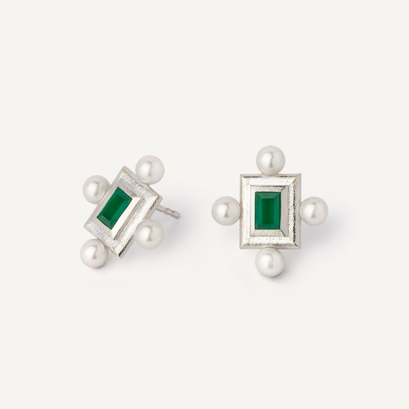 A pair of silver earrings featuring a geometric design with a central green gemstone surrounded by pearls, set in a rectangular shape. Handmade jewel. 