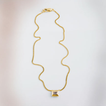 A gold plated silver necklace with a reversible pendant featuring a green Peridot gemstone on one side and violet Amethyst on the other designed for everyday wear.