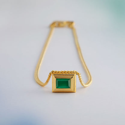 A gold plated silver necklace with a reversible pendant featuring a green Chrysoprase gemstone on one side and blue Topaz on the other designed for everyday wear.